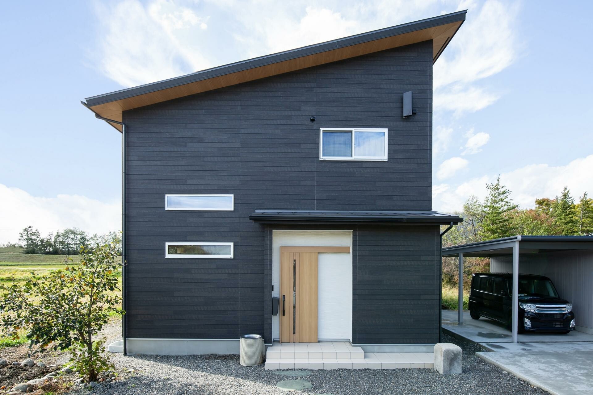 濃い外壁色で落ち着いた印象に仕上げた住宅